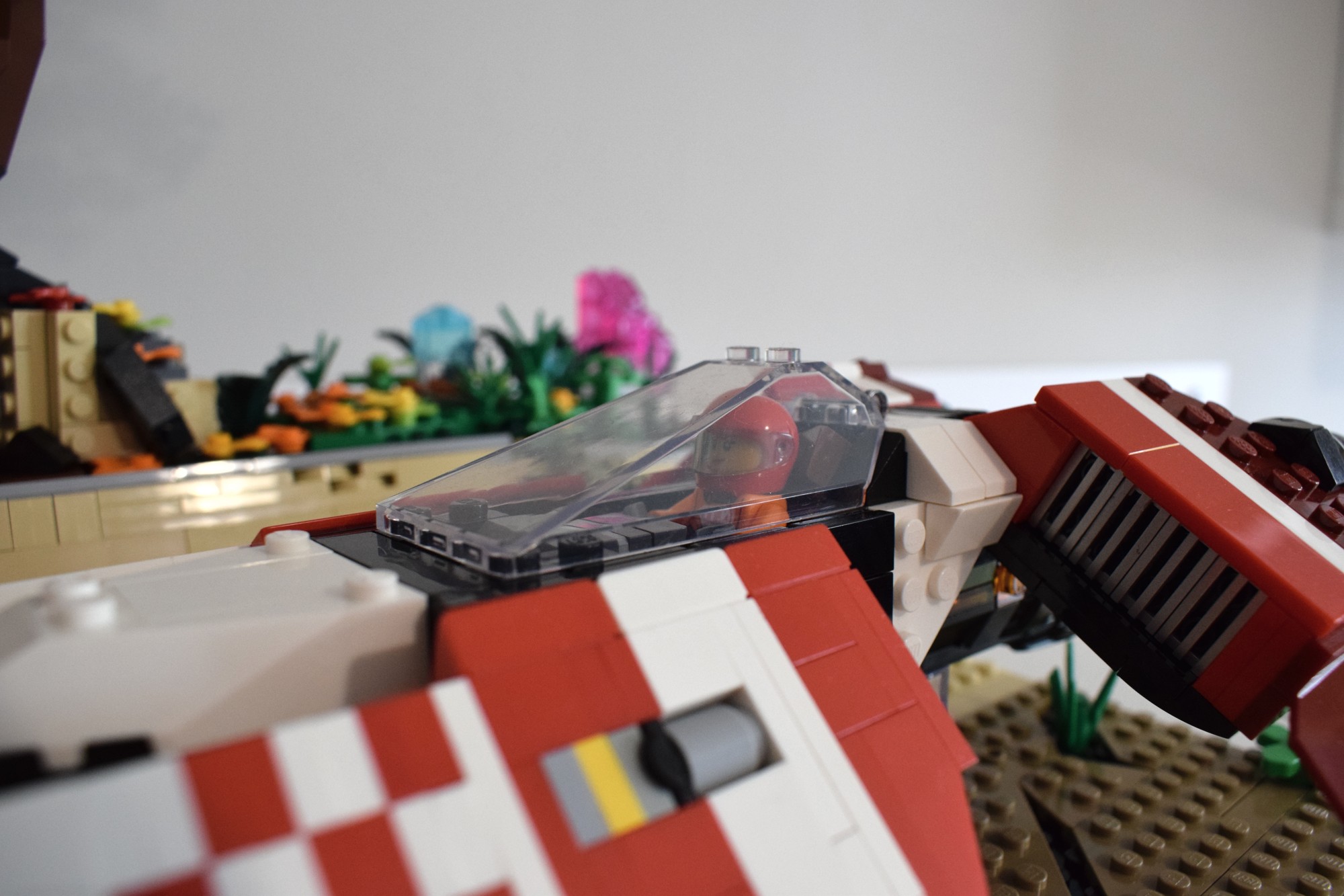 Closeup of the minifigure pilot in the racing vehicle. They are squeezed tightly into the small cockpit, much like a fighter pilot.